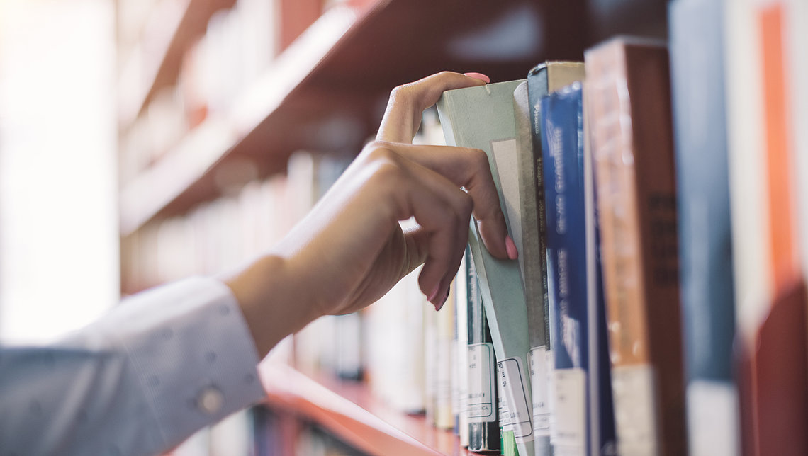 Mitarbeiterin am Bücherregal