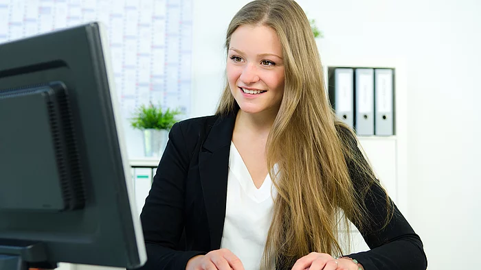 Junge Frau sitzt am Schreibtisch