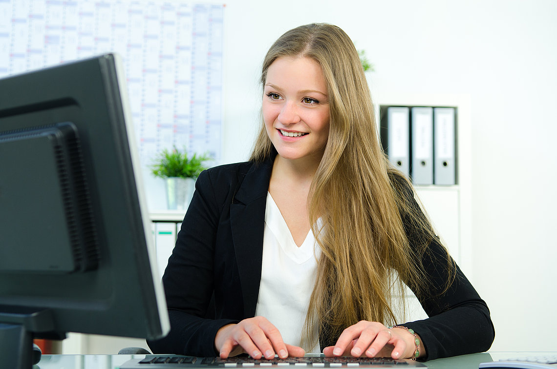 Junge Frau sitzt am Schreibtisch