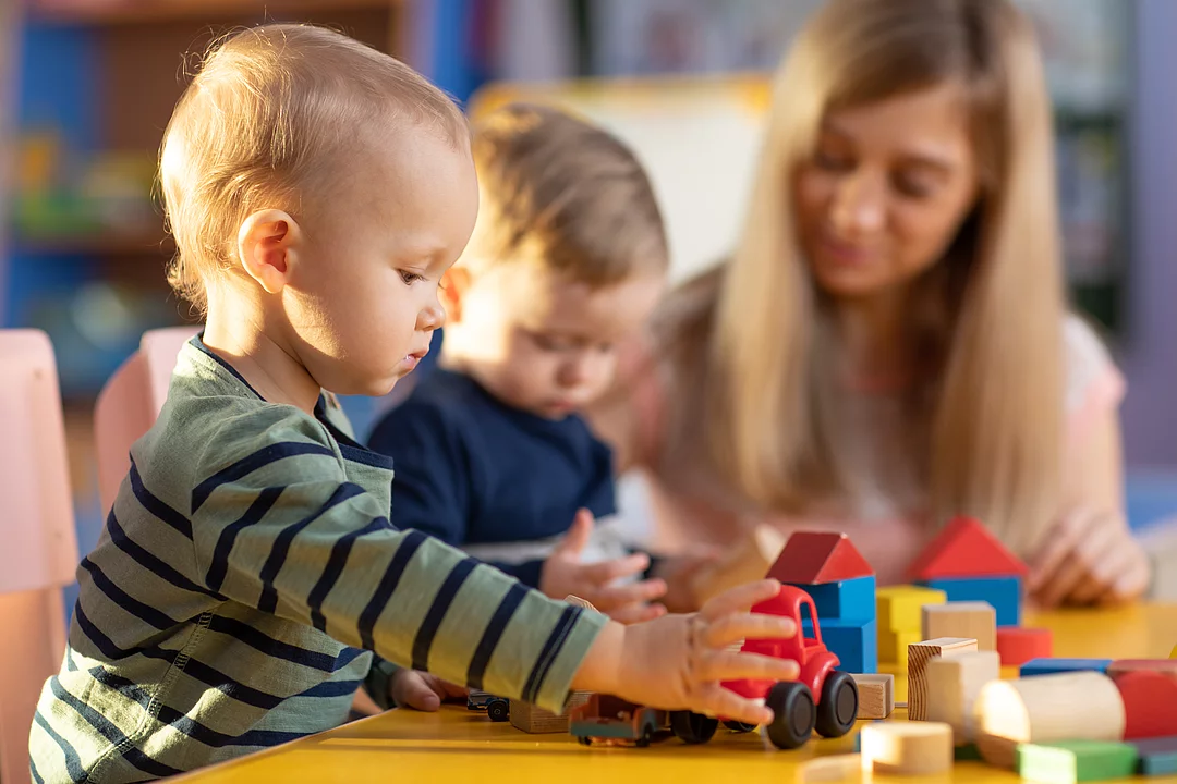 Krippenkinder beim Spielen mit Bauklötzen.