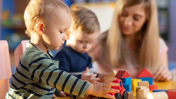 Krippenkinder beim Spielen mit Bauklötzen.