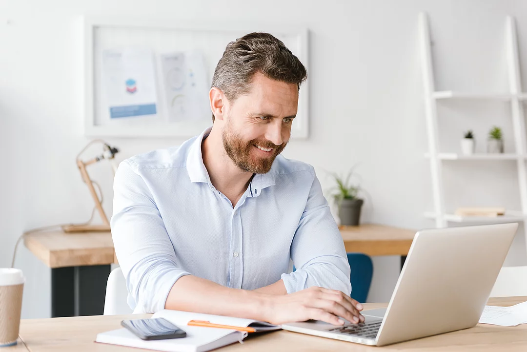 Mann arbeitet am Laptop