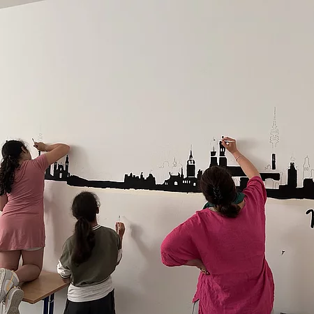 Kinder gestalten eine Wand.