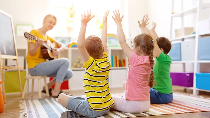 Kiga: Erzieherin spielt Gitarre